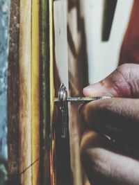 Close-up of person working on metal