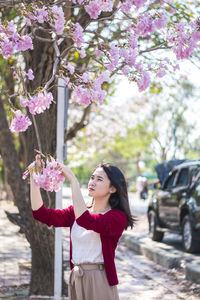 Young woman holding pink flowers