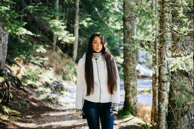 Portrait of young woman standing in forest