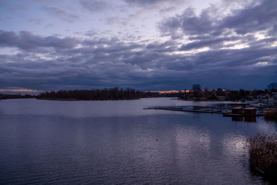 Scenic view of lake against sky in city