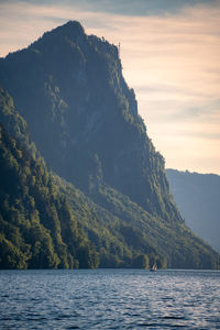 Scenic view of sea and mountains against sky during sunset