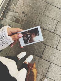 High angle view of woman photographing with mobile phone