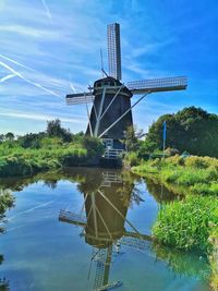 Traditional windmill on landscape against sky