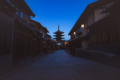 Street amidst buildings against sky at dusk