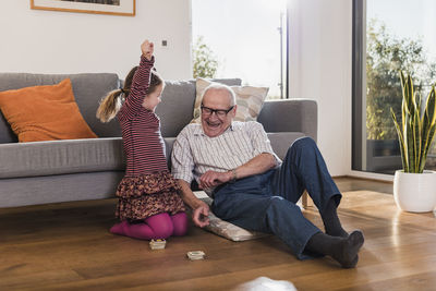 Grandfather and granddaughter playing memory, girl celebrating victory