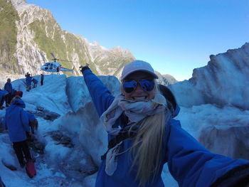 Portrait of young woman against mountains during winter