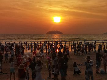 Group of people on beach during sunset