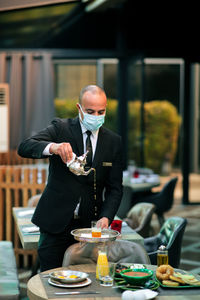 Waiter pouring tea in restaurant