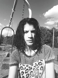 Portrait of young woman in playground against sky