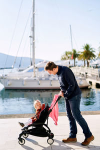 Father and daughter standing at harbor