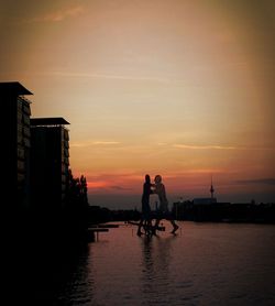 Silhouette people in boat at sunset