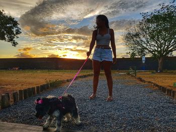 Woman with dog against sky