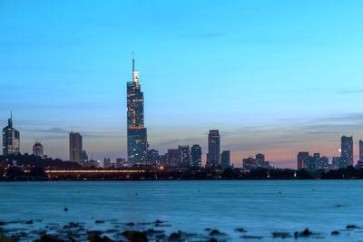 Illuminated buildings in city at waterfront