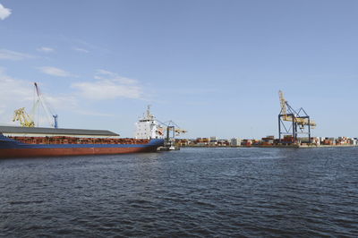 Commercial dock by sea against sky