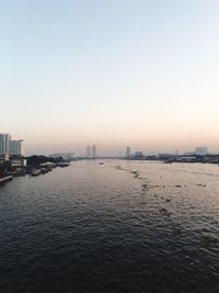 Scenic view of sea and buildings against clear sky