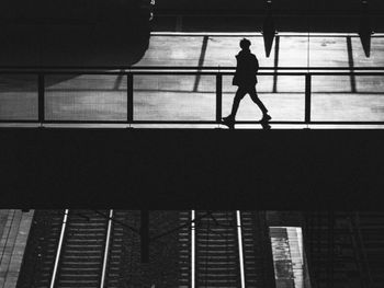 Low angle view of silhouette people walking on escalator