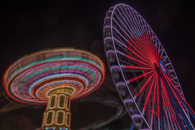 Low angle view of illuminated ferris wheel against sky at night