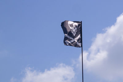 Low angle view of flag against blue sky