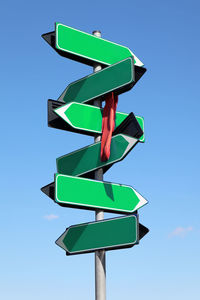 Blank green road sign against blue sky and clouds.