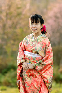 Young woman smiling while sitting on tree