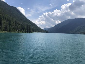 Scenic view of lake by mountains against sky