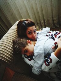 Portrait of mother with son lying on bed at home