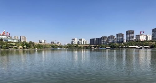 Scenic view of lake by buildings against clear sky