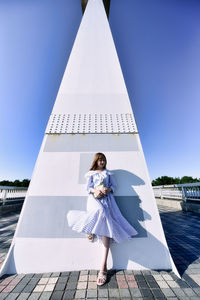 Woman standing against blue sky