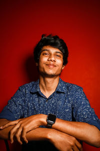 Portrait of young man standing against yellow background