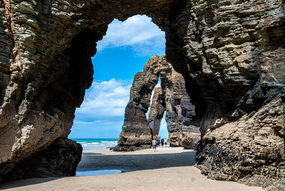 Rock formations by sea against sky