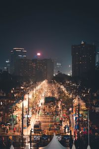 Illuminated buildings in city against sky at night