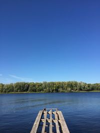 Scenic view of lake against clear blue sky