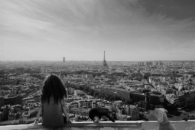 Rear view of woman with cityscape in background