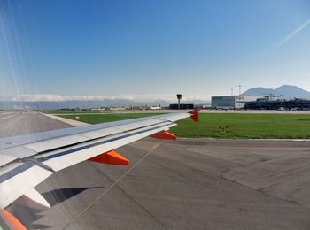 Airplane on airport runway against clear blue sky