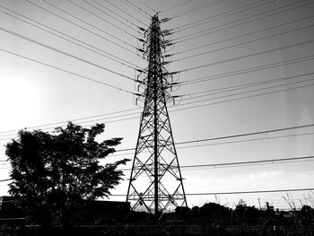 Low angle view of silhouette electricity pylon against sky