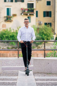 Full length portrait of young man standing in city