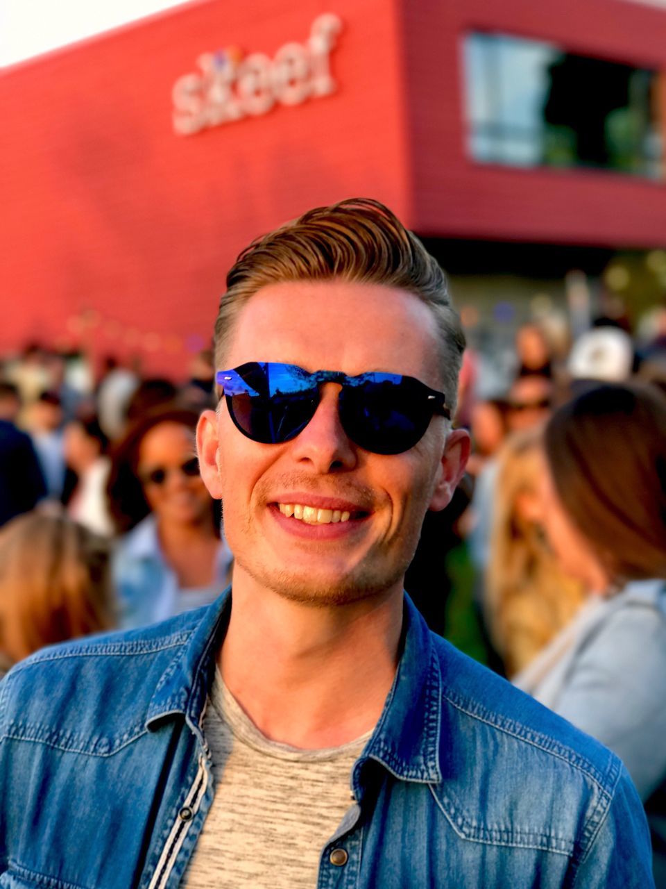 PORTRAIT OF SMILING MAN WEARING SUNGLASSES AT MUSIC CONCERT