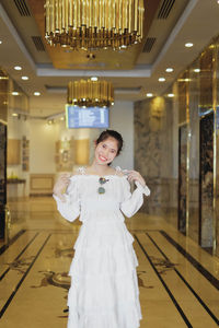 Portrait of smiling woman standing in corridor