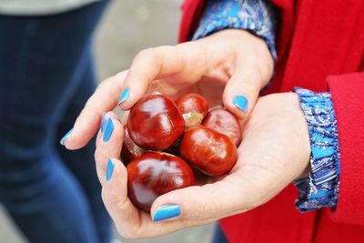 Midsection of woman holding chestnuts outdoors