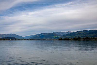 Scenic view of lake by mountains against sky