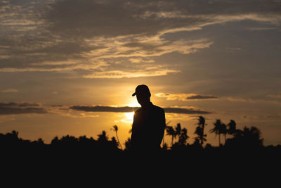 Silhouette man standing against orange sky