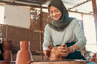 Portrait of smiling young woman standing at home