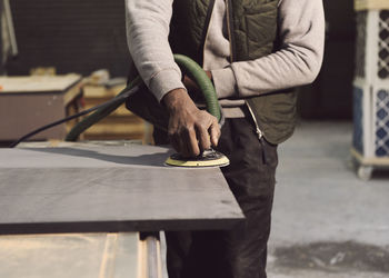 Midsection of carpenter working at workshop