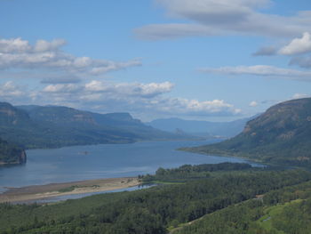 Scenic view of sea and mountains against sky