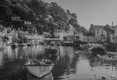 Boats moored on river against houses