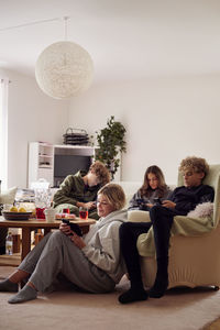 Family using smart phones in living room