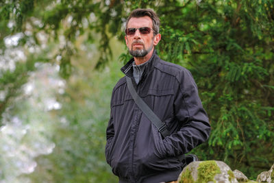 Portrait of man standing against plants