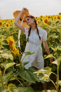 Young woman standing by plants