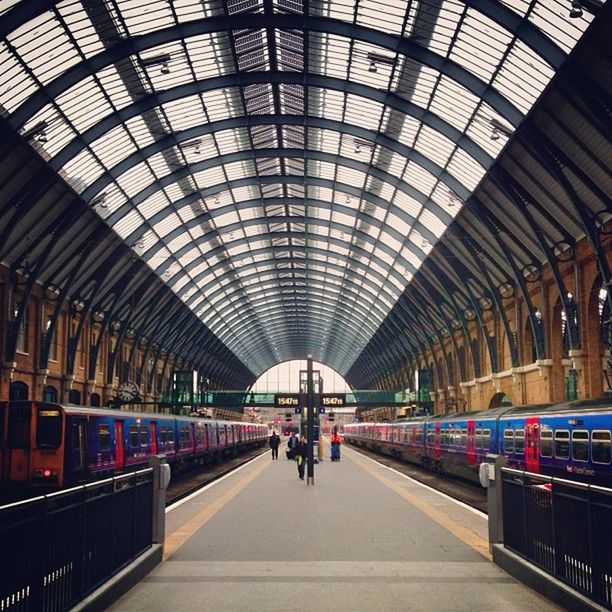 indoors, ceiling, architecture, railroad station, transportation, public transportation, railroad station platform, built structure, rail transportation, subway station, incidental people, the way forward, travel, transportation building - type of building, diminishing perspective, men, railroad track, illuminated, subway