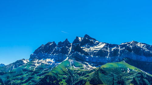 Scenic view of snowcapped mountains against clear blue sky